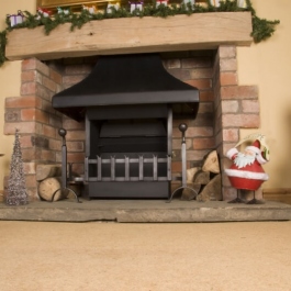 Thermovent convecting open fire in a medium size fireplace at Christmas time. Swan neck dog irons with ball tops and fish tail grate front.