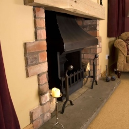 A medium size open fireplace in a new extension featuring a Thermovent high performance wood burning open fire with steel canopy