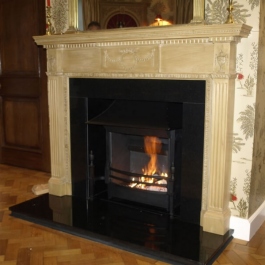 Polished granite & wood fire surround with steel canopied high performance woodburning open fire with built in flue baffle and convection system