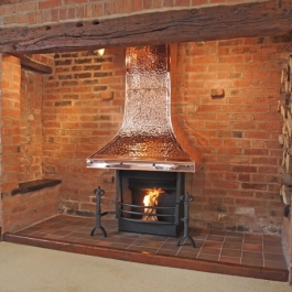 Thermovent high performance convecting open fire with large copper canopy and hand cast iron Fleur de lis dog irons